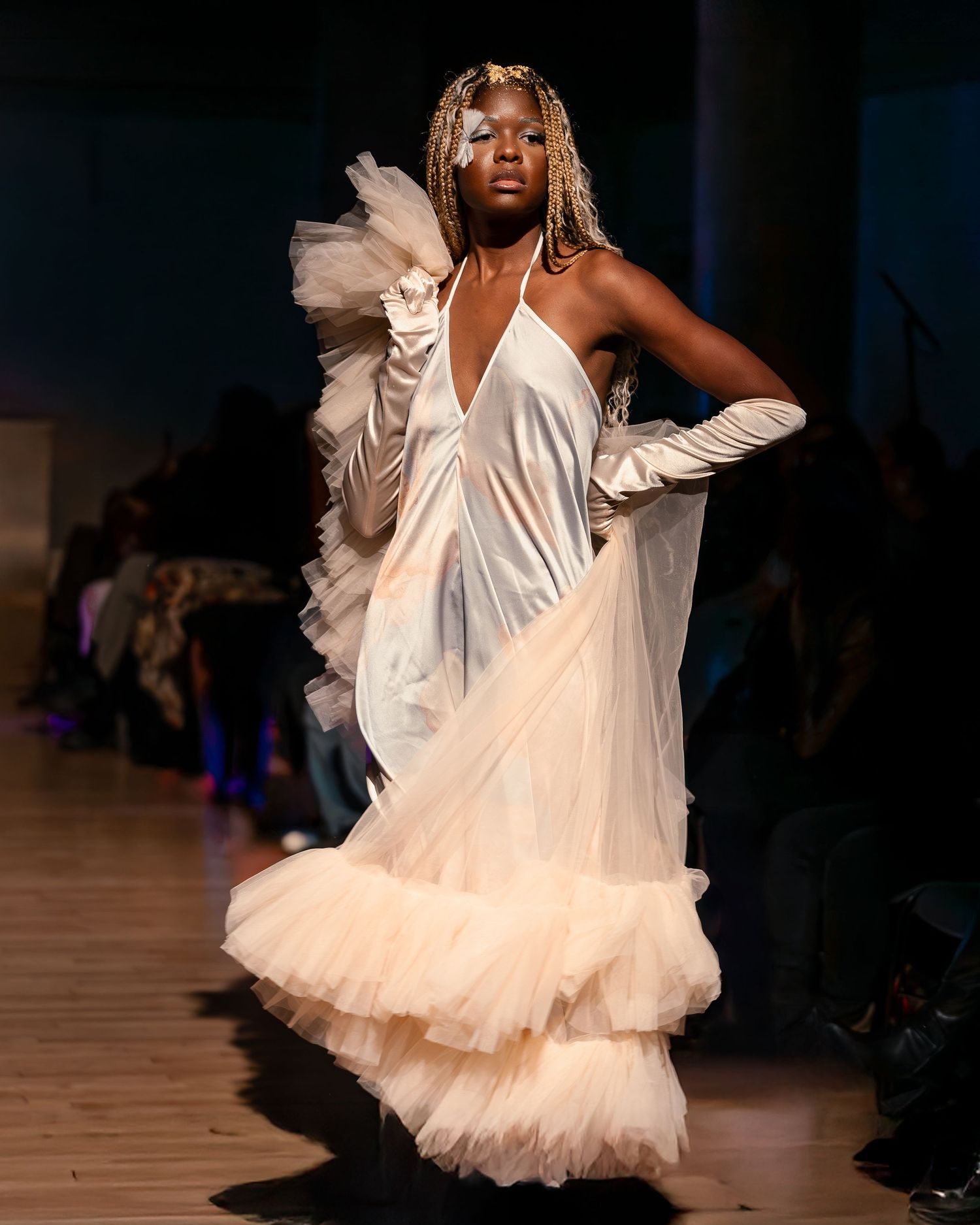 A model in a white gown walking a runway, the skirt in motion.